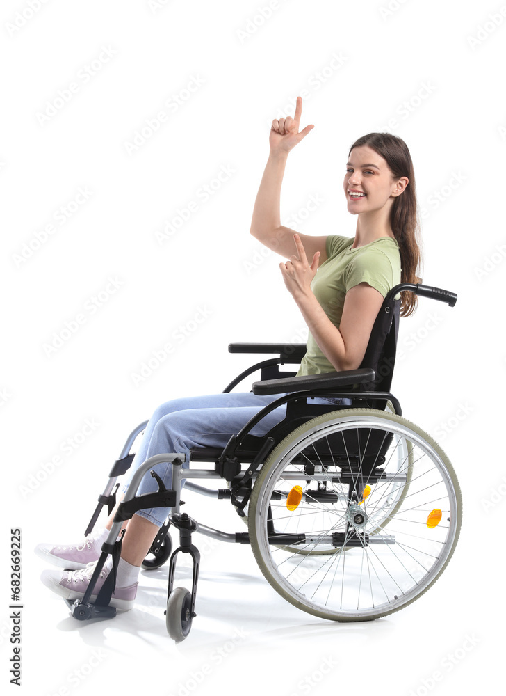 Young woman in wheelchair pointing at something on white background Young woman in wheelchair pointing at something on white background