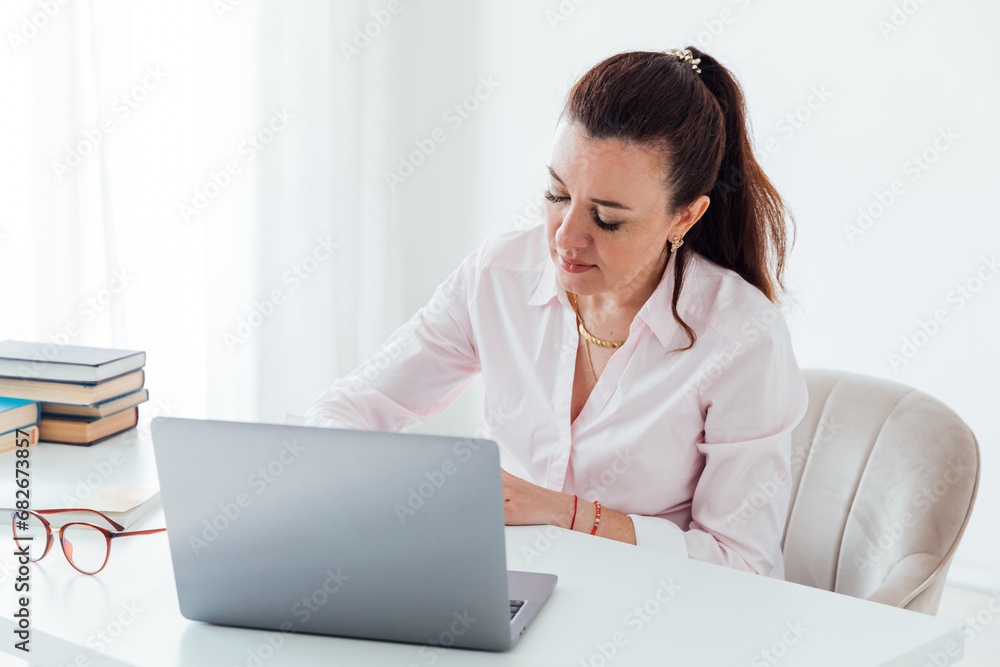 Business woman recording information from laptop Business woman recording information from laptop