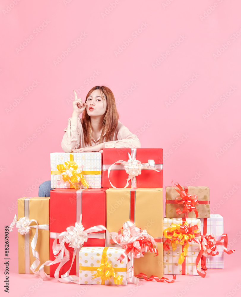 Photo of pretty adorable woman in pink shirt standing holding stack of gift boxes over pink studio background. celebrating women's day, valentine's, birthday, anniversary. shopping for holiday concept Photo of pretty adorable woman in pink shirt standing holding stack of gift boxes over pink studio background. celebrating women's day, valentine's, birthday, anniversary. shopping for holiday concept