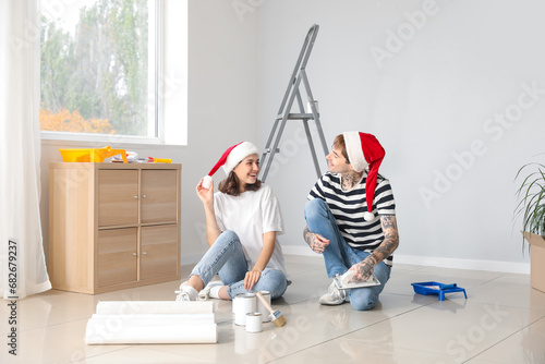 Young couple with Santa hats during repair in their new house