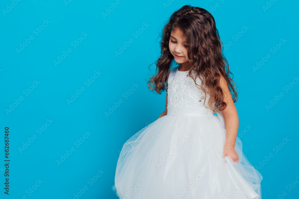 Beautiful little girl in white dress on blue background Beautiful little girl in white dress on blue background