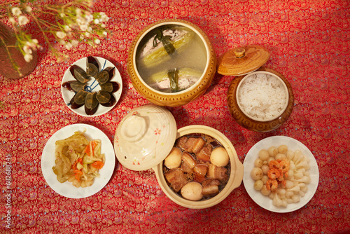 Vietnamese table food for Tet, traditional food on lunar new year: pork belly with hard-boiled eggs braised in coconut water, mixed pickles, rice and other Tet foods on background