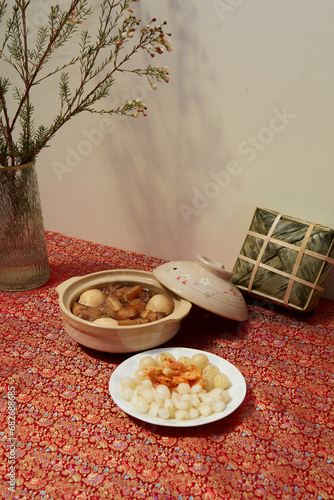 Vietnamese table food for Tet, traditional food on lunar new year: pork belly with hard-boiled eggs braised in coconut water, mixed pickles, rice and other Tet foods on background