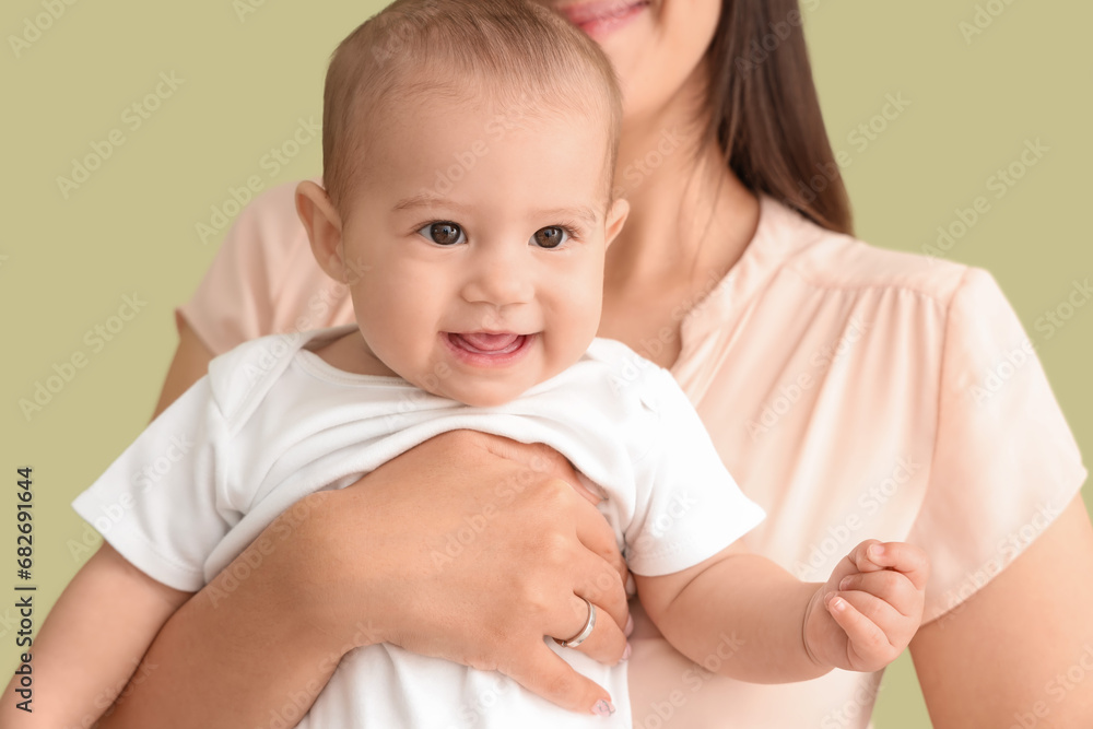Happy mother with her little baby on green background, closeup