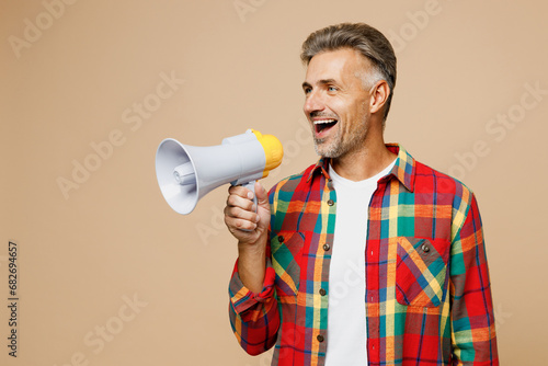 Adult man wear red shirt white t-shirt casual clothes hold in hand megaphone scream announces discounts sale Hurry up isolated on plain pastel light beige color background studio. Lifestyle concept.