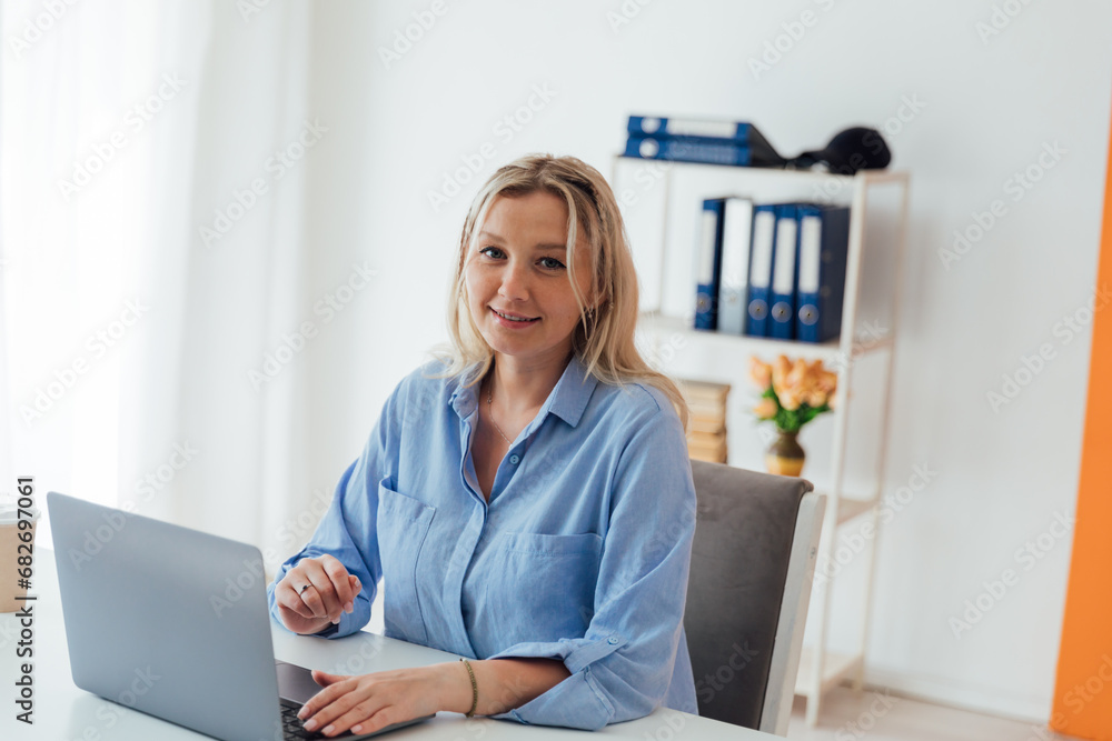 Businesswoman working on laptop at desk in office at home Businesswoman working on laptop at desk in office at home