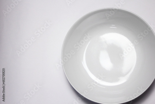 Empty white plate on white background with copy space. Top view.