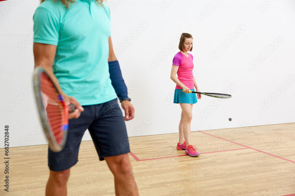 Crop shot of male athlete in sportswear playing squash