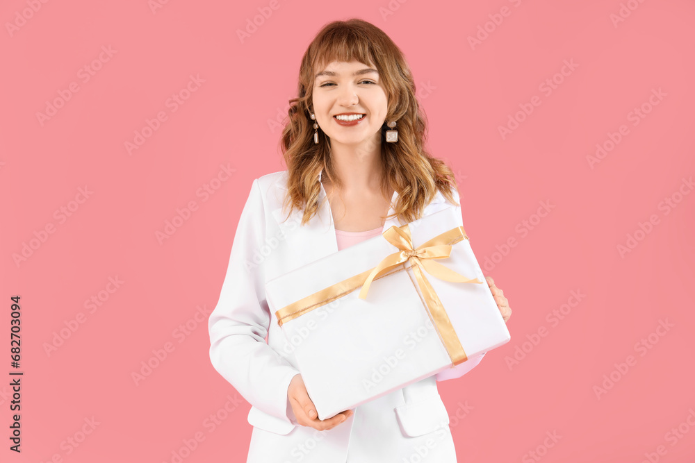 Beautiful young woman with gift box on pink background Beautiful young woman with gift box on pink background