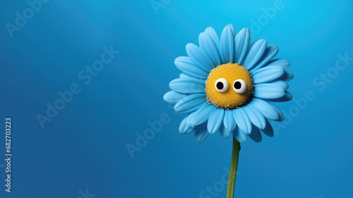 Blue daisy with googly eyes on blue background with copy space. Blue Monday photo