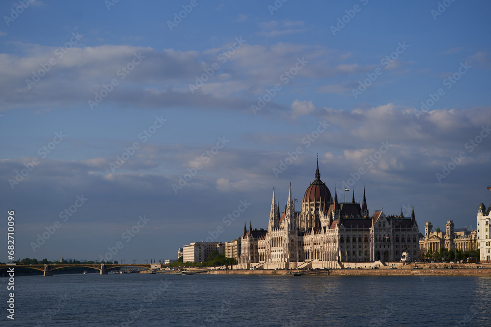 Panoramic view on beautiful Hungarian Parliament Building (Hungarian: Országház) on the embankment of river Danube at sunset. Budapest, Hungary - 7 May, 2019