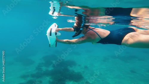 Underwater scooter. Woman swims using modern innovative diving gadget. photo