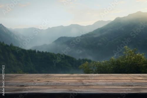 Wooden table overlooking a misty mountain valley at sunrise.