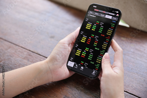 Wallpaper Mural Woman hand using a smartphone for Stock exchange trading online in the coffee shop, business concept Torontodigital.ca