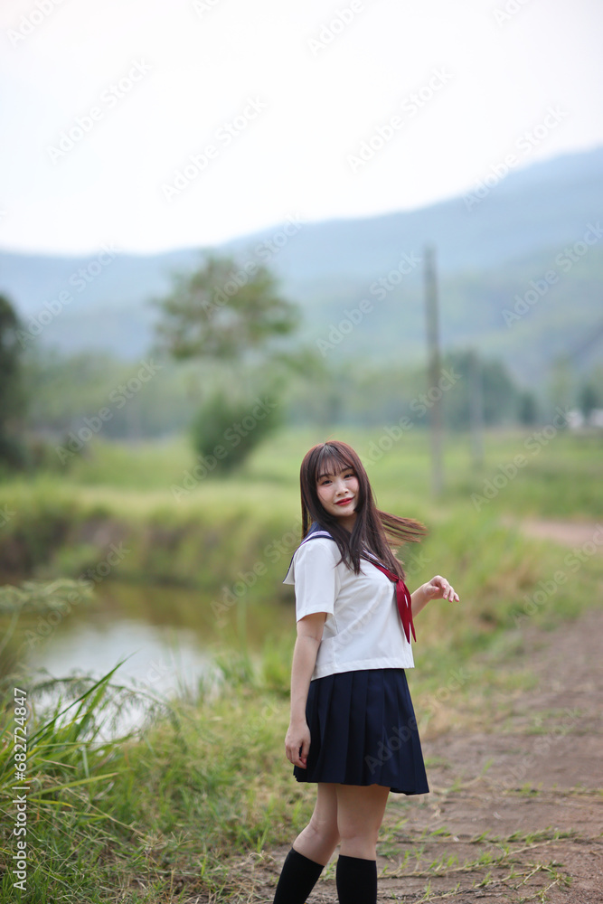 Japanese high school student looking on countryside background Japanese high school student looking on countryside background