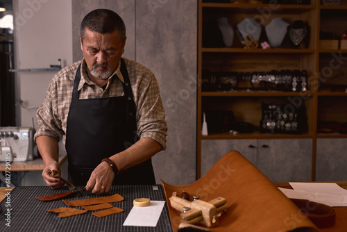 successful hardworking man use oil to soften leather. close up portrait. copy space. photo