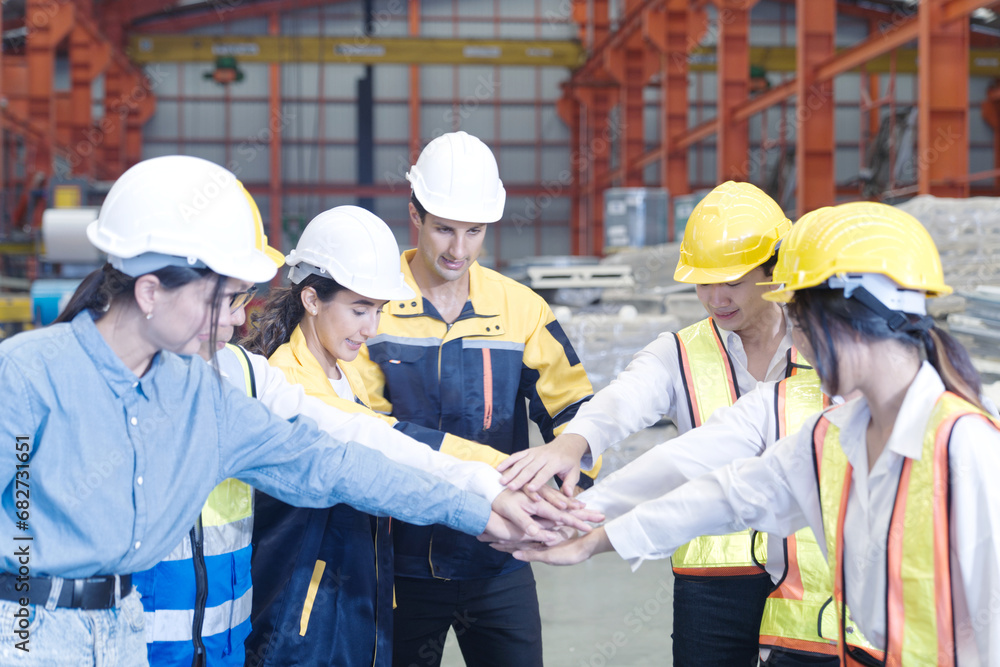 Group of engineers and technicians join hands together in factory, Industrial teamwork concept. Group of engineers and technicians join hands together in factory, Industrial teamwork concept.
