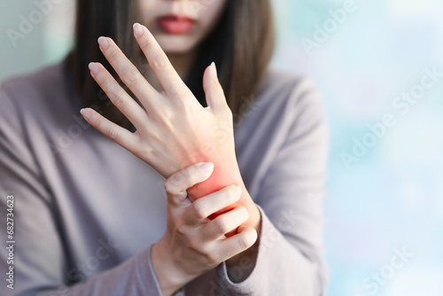 A woman squeezes a wrist that is inflamed due to arthritis. photo