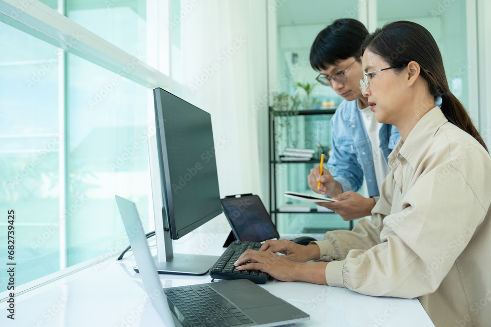 IT programmers working together at office desk. IT programmers working together at office desk.