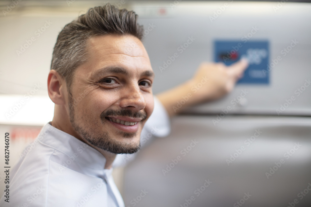 Fototapeta premium smiling man using tablet while standing in food factory