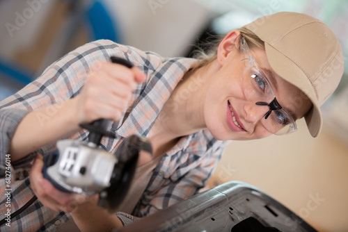 female worker using glasses saws with a circular saw