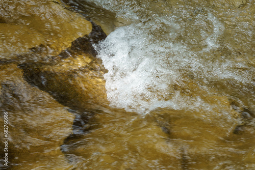 Fast mountain river and stones. Close-up of through the fast flowing water. Olkhovka river in Kislovodsk national Park. photo