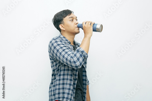Portrait Asian Indonesian man showing drinking water from tumbler bottle photo