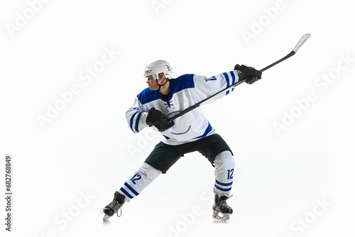 Man, ice hockey player in motion during game with stick, training, playing against white studio background © Lustre Art Group 