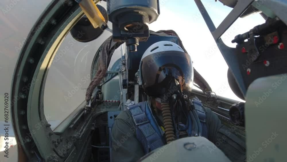 A pilot in a helmet inside the cockpit of a fighter A pilot in a helmet inside the cockpit of a fighter