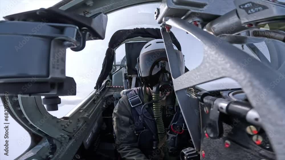 A pilot in a helmet inside the cockpit of a fighter A pilot in a helmet inside the cockpit of a fighter