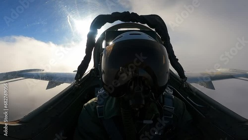 A pilot in a helmet inside the cockpit of a fighter photo