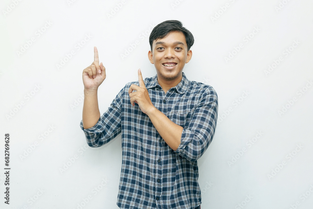 Portrait Indonesian Asian young man with index fingers pointing up. Casual concept isolated white background Portrait Indonesian Asian young man with index fingers pointing up. Casual concept isolated white background