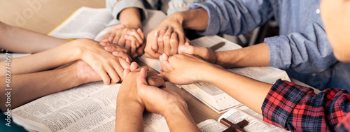 Fotografie Cropped image of diversity people hand praying together at wooden church on bible book while hold hand together with believe
