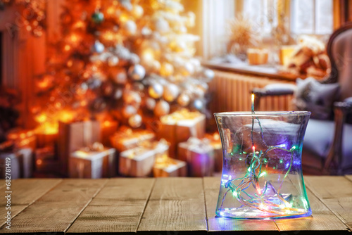 Wooden table and christmas small lights decoration. Free space for your decoration. Blurred background of home interior with window and christmas tree. Mockup background and natural lights. 