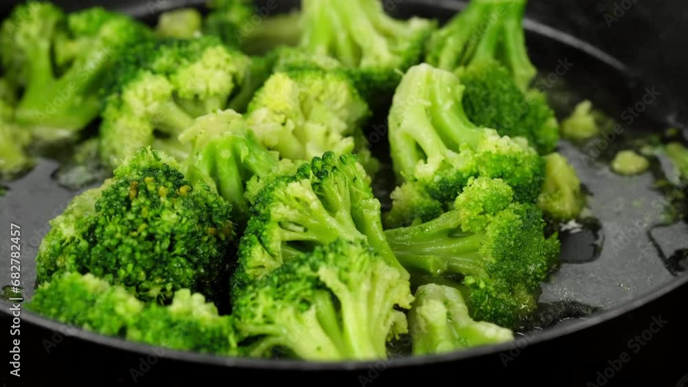 Chef stirring and frying broccoli on a pan. Healthy food, vegetarian cuisine Chef stirring and frying broccoli on a pan. Healthy food, vegetarian cuisine