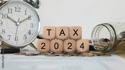 Tax wooden letter and 2024 number on wooden block.Pay tax Income Statement. paying the tax rate. Taxation, taxes burden. Business concept.
