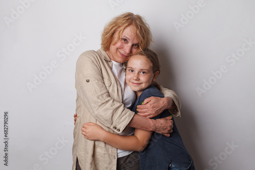 Happy family. Cute grandma and little child girl smiling on grey background photo