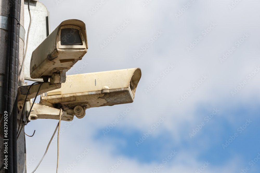 two old CCTV surveillance cameras on street pole at summer day two old CCTV surveillance cameras on street pole at summer day