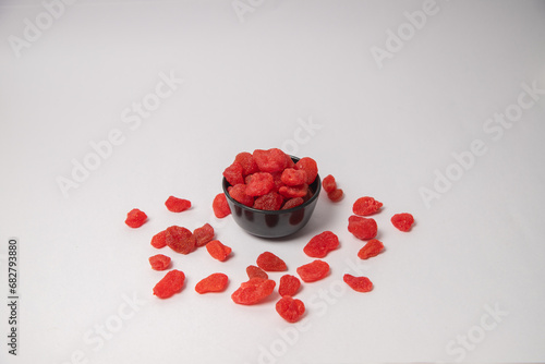 Dried strawberry fruit on white bowl with white background, Dried strawberries scattered on the white background in a black bowl or vessel