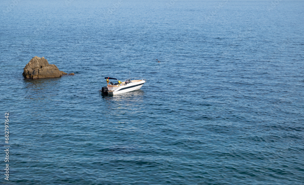 Beautiful view of white boat and people swimming in the sea