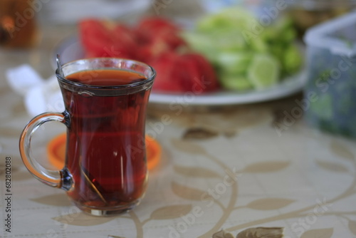 Closeup Turkish tea in traditional glass with tomatoes and cucumber