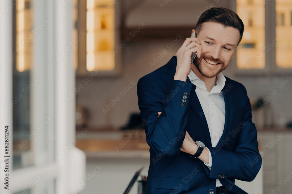 Happy executive director in stylish suit and with phone indoors Happy executive director in stylish suit and with phone indoors