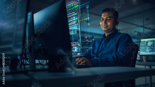 Futuristic Office with Hologram Screens: Professional Indian IT Programmer Working on Computer with Holographic Projection Showing Data and Charts. Asian Specialist Creating Innovative Software. photo