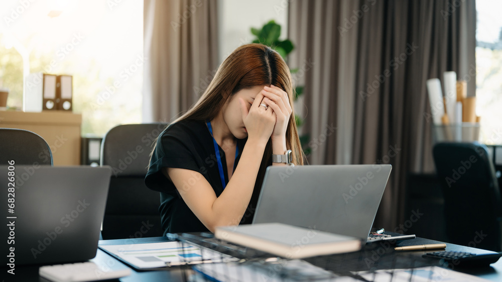 Asian business woman is stressed, bored, and overthinking from working on a tablet . Asian business woman is stressed, bored, and overthinking from working on a tablet .