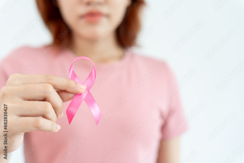 Woman hold pink ribbon breast cancer awareness. Female health check consciousness. international Women Day and World Cancer Day. sign cancer, Symbolic, health care, support patients, timely diagnosis Woman hold pink ribbon breast cancer awareness. Female health check consciousness. international Women Day and World Cancer Day. sign cancer, Symbolic, health care, support patients, timely diagnosis