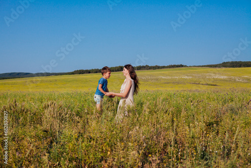 Mother and son walking in the nature of a rural field