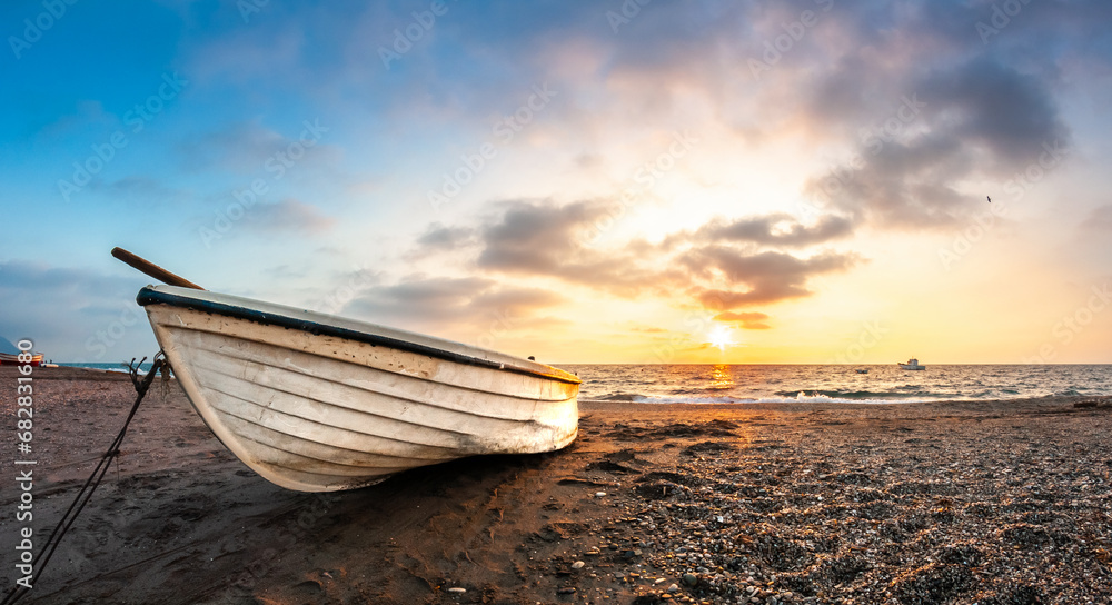 The boat rests on the sand when the sun sets