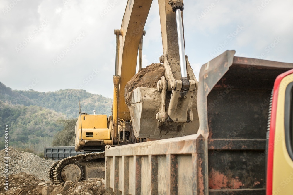 Fototapeta premium A photograph of the heavy machinery at the quarry, rocks and sand conveyor belt.