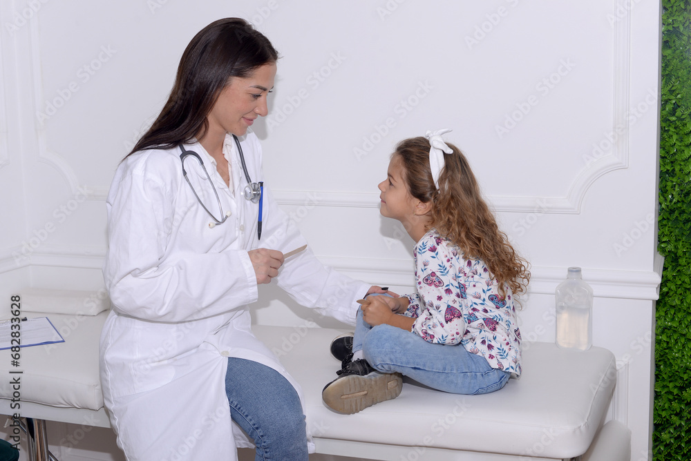 Pediatrician examining little child patient’s throat at clinic Pediatrician examining little child patient’s throat at clinic