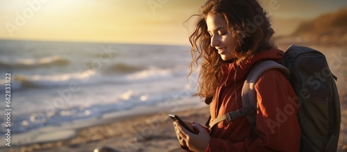 Portrait Young woman traveler with backpack and mobile phone on the seashore. AI generated image
